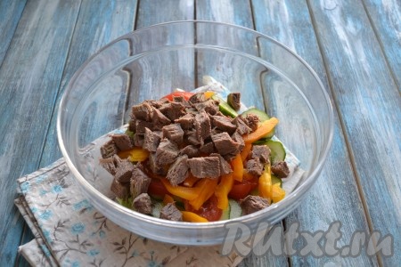 Остывшую отваренную говядину нарезать на кубики размером 1х1 сантиметр и выложить в салат с овощами.