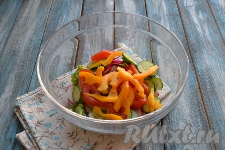 Из болгарского перца удалить семена и плодоножку, промыть его водой, нарезать тонкой соломкой и тоже выложить в миску с овощным салатом.