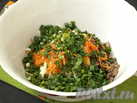 В глубоком салатнике смешать печень, яйца, морковь по-корейски (если морковь очень длинная, её можно разрезать на несколько частей) и зелень.
