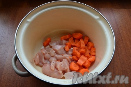 Куриное филе нарезать кусочками и поместить в кастрюлю. Сюда же добавить нарезанную морковь.