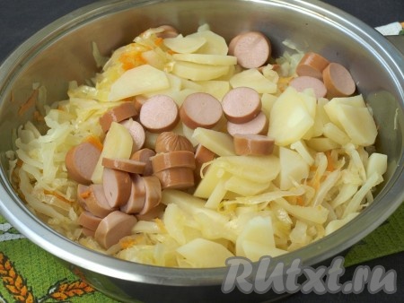 В сковороду к капусте добавить картофель с сосисками.
