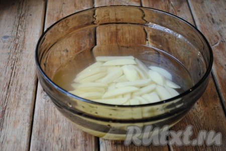 Нарезанные ломтики картофеля залить чистой холодной водой и оставить в воде на 10-15 минут. Это нужно для того, чтобы смыть с картофеля крахмал. 