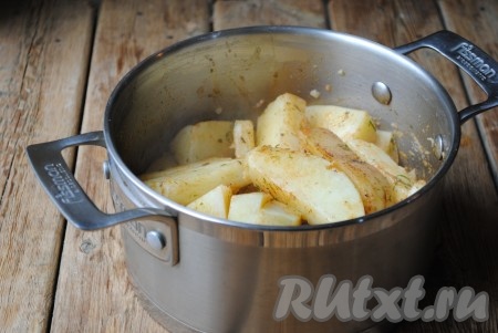 Накрыть кастрюлю крышкой и аккуратно встряхнуть, чтобы ароматная смесь равномерно распределилась по ломтикам картофеля.
