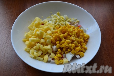 Яблоко, очищенное от кожуры и семян, нарезать кубиками и вместе с кукурузой добавить в салат из крабовых палочек и яиц.
