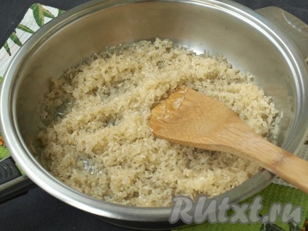 Сковороду разогреть, влить подсолнечное масло. Добавить рис и хорошо размешать, чтобы каждое зёрнышко покрылось маслом. В дальнейшем это позволит остаться рису рассыпчатым. Обжаривать на среднем огне. Рис сначала станет прозрачным. 

