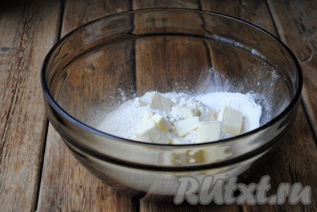 Для приготовления теста нужно просеять в миску муку, добавить сахар, щепотку соли, разрыхлитель и холодное сливочное масло. Масло лучше всего нарезать кубиками или натереть на крупной тёрке. 