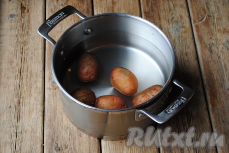 Подготовить необходимые ингредиенты для приготовления в духовке картофельных палочек. Картошку вымыть, залить полностью водой и отварить в мундире до готовности. Слить воду и дать картофелю полностью остыть.
