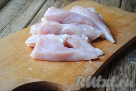 Куриное филе вымыть, обсушить, затем нарезать длинными полосками, которые нужно разрезать пополам. Ширина полосок должна быть, примерно, 1,5-2 сантиметра. 
