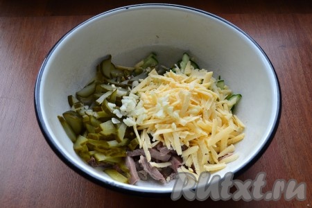 Затем добавить в салат с языком и огурцами измельченный чеснок и твердый сыр, натертый на крупной терке.
