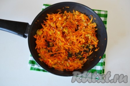 В разогретую сковороду влить растительное масло и через минуту выложить лук с морковью. Помешивая, обжарить на среднем огне в течение 1-2 минут. Лук должен стать мягким и прозрачным.
