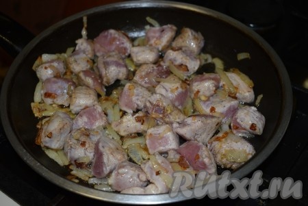 Затем добавить к луку кусочки свинины и жарить на среднем огне до подрумянивания мяса.
