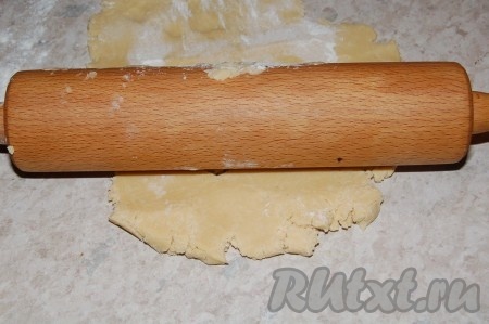 Через час принести тесто и раскатать из него пласт. Если раскатывать не получится (из-за хрупкости теста), то руками распределить тесто по форме для выпекания.