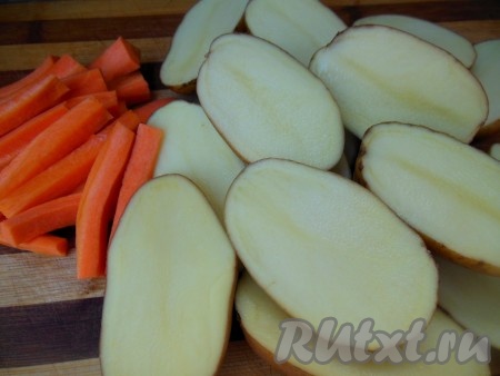 Картофель и морковь вымойте. Морковь очистите и нарежьте на брусочки. Картофель с кожурой разрежьте на две части. Слегка посолите овощи, можно добавить по вкусу черный молотый перец.
