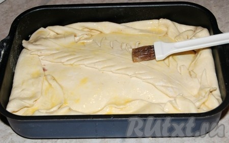 Накрыть начинку вторым раскатанным пластом теста. Смазать верх пирога разболтанным яйцом и сделать дырочки (вилкой или ножом), чтобы выходил пар.