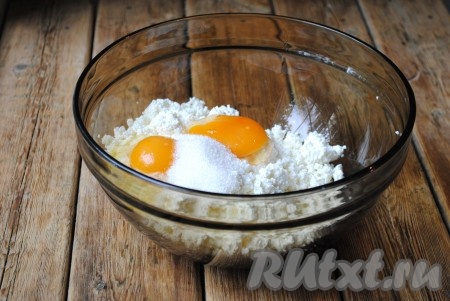 К творогу добавить яйца, щепотку соли и сахар.