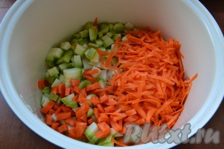 Далее добавить в чашу капусту, кабачки и очищенную натёртую на крупной тёрке морковь, перемешать и снова включить программу "Выпечка" на 10 минут, обжаривать овощи, периодически помешивая.