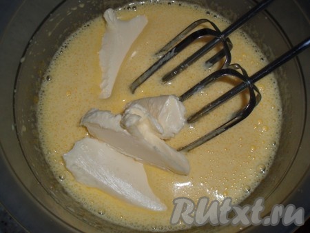 Добавить к яйцам с сахаром нарезанное на кусочки сливочное масло комнатной температуры и продолжить взбивание.