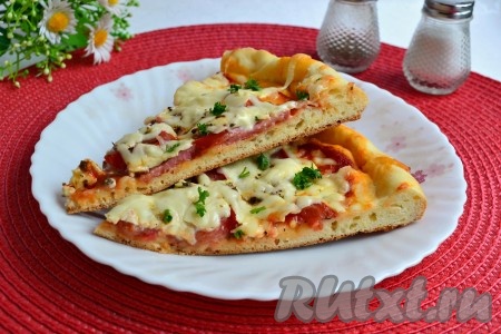 Необычайно вкусную пиццу с помидорами, колбасой и сыром, испеченную в духовке по этому простому рецепту, нарезать и подать к столу в теплом виде. 