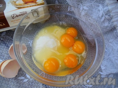 В глубокую миску насыпьте сахар, добавьте куриные яйца.
