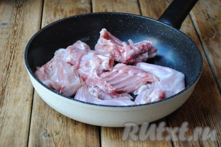 Сковороду с небольшим количеством растительного масла хорошо разогреть. Выложить на сковороду мясо кролика и обжарить на большом огне с двух сторон до румяной корочки. 
