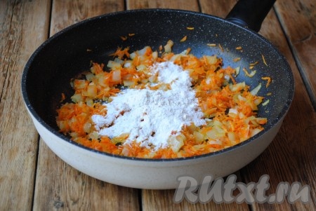 Обжаривать морковку с луком на небольшом огне, периодически помешивая, около 5 минут. Овощи должны стать мягкими. Затем всыпать муку и хорошо перемешать. Жарить, иногда помешивая, ещё пару минут. 
