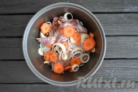 Выложить кролика в чашу мультиварки. Репчатый лук и морковку очистить, нарезать кольцами и выложить к мясу.

