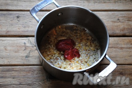 Обжаривать лук на среднем огне, помешивая, до румяного цвета (около 3-4 минут), затем добавить томатную пасту. 
