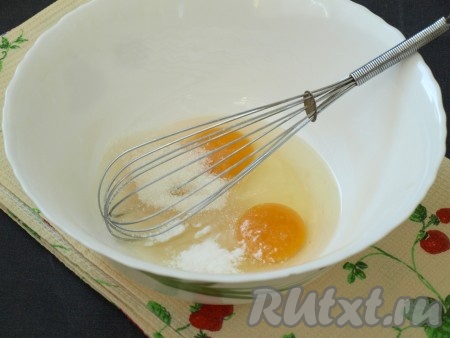 В миску разбить яйца и добавить к ним сахар и ванилин. При помощи венчика массу тщательно взбить.
