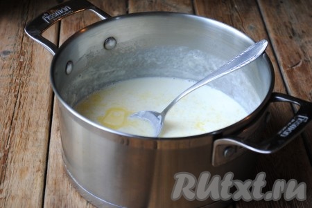 Когда рис сварится, добавить в молочную рисовую кашу сливочное масло, перемешать, накрыть кастрюлю крышкой и оставить на 5 минут. 
