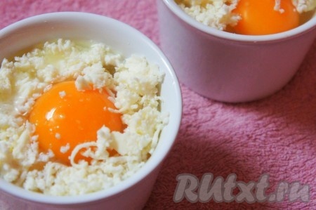 Аккуратно вбить в каждую форму по яйцу, немного посолить, добавить оставшийся сыр. 