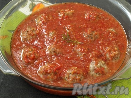 Достать форму из духовки и залить тефтели томатным соусом, сверху добавить веточку свежего розмарина. Форму прикрыть фольгой и снова поставить в духовку на 30 минут. 