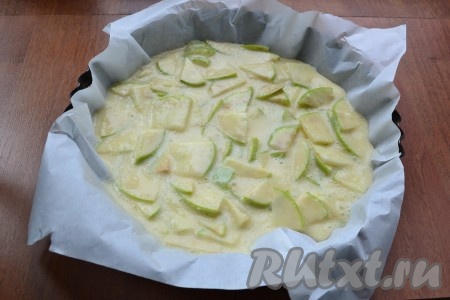 Форму диаметром не более 20 см застелить пергаментом и немного смазать сливочным маслом. Выложить в форму тесто с яблоками.