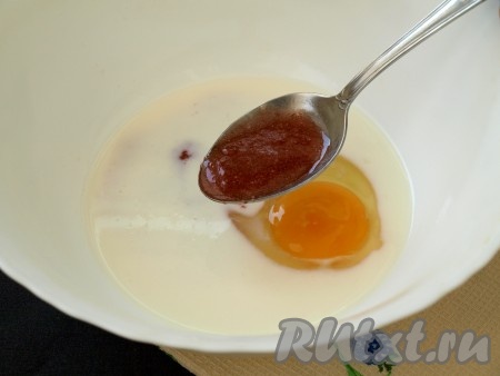 Вылить в миску часть молока комнатной температуры и добавить яйцо. Также добавить клубничный джем (джем - это, по сути, свежая клубника, перетёртая с сахаром, в пропорции 1:2).
