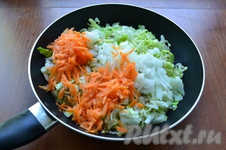 Сковороду поставить на огонь, добавить к капусте мелко нарезанный репчатый лук и натертую на крупной терке морковь.
