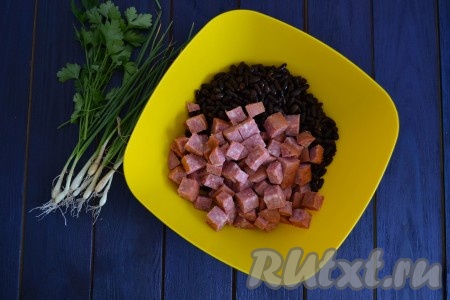 Копченую колбасу нарезать для салата и кубиками размером, примерно, 1х1 см и выложить к фасоли.
