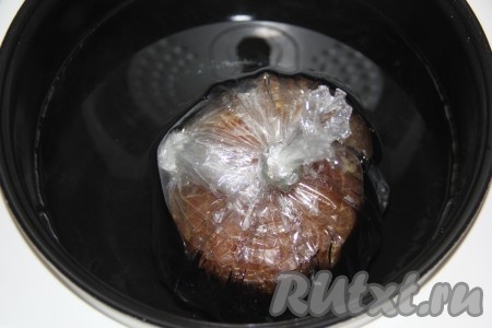 Положить мясо в пакете для запекания в чашу мультиварки и залить горячим кипятком так, чтобы вода полностью покрыла пакет с мясом. Закрыть крышку мультиварки и выставить режим "Тушение" на 2 часа. 
