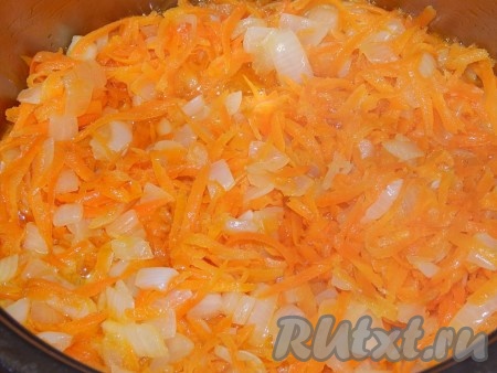 Теперь приготовим зажарку для нашей закуски. На крупной терке натираем морковь. Не очень крупно режем лук. В разогретую сковороду наливаем немного растительного масла и на слабом огне обжариваем лук, иногда помешивая, до прозрачности, затем выкладываем на сковороду морковь и обжариваем до легкого размягчения. Солим и перчим зажарку по вкусу. Сильно лук с морковкой поджаривать не нужно, они должны быть томлеными.