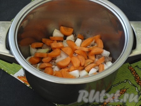 Очищенную морковку нарезать полукружками. Очищенный лук нарезать кубиками. Выложить лук с морковью в кастрюлю к обжаренной говядине.
