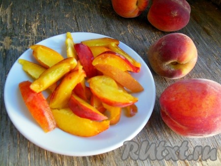 Персики хорошо вымойте и, удалив косточку, разрежьте на небольшие дольки.
