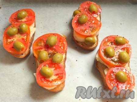 Выложить помидоры на моцареллу, посыпать солью и перцем. Оливки разрезать пополам и произвольно выложить поверх бутербродов.
