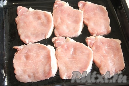 Свинину нарезать на плоские кусочки толщиной, примерно, 1,5-2 см, слегка отбить каждый кусочек мяса. Противень смазать растительным маслом и выложить на него кусочки свинины.