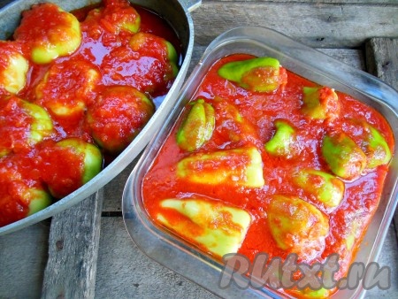В глубокую форму выложите фаршированные перцы в один слой, сверху залейте приготовленной томатной подливкой.
