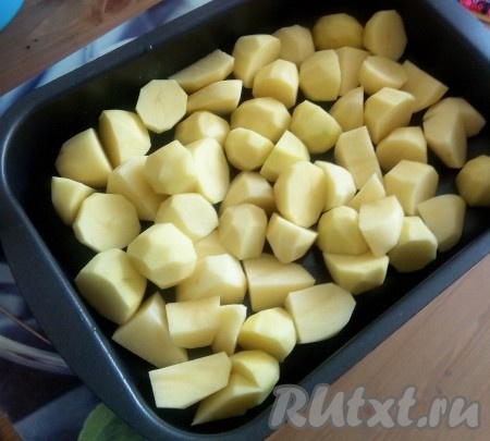 Картофель очистить, вымыть, нарезать средними кубиками, уложить в форму, смазанную растительным маслом.