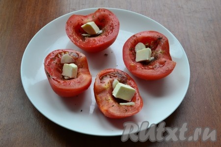 В каждую половинку помидора поместить по кусочку сливочного масла.