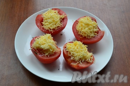 Отправить помидоры в микроволновку на 3 минуты при мощности 750 Ватт. Затем помидоры вынуть, посыпать их тертым твердым сыром.
