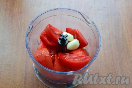 Нарезать помидоры и вместе с очищенными зубчиками чеснока поместить в чашу блендера.