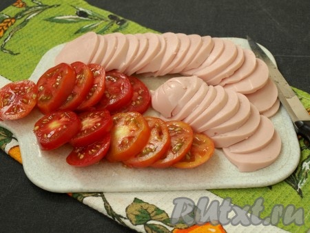 Тонкими кружочками нарезать колбасу и помидоры.
