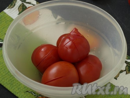 На верхушке помидоров сделать крестообразный надрез и опустить на несколько секунд помидоры в кипяток, затем сразу окунуть помидоры в холодную воду. Снять шкурку. Если вас не смущает шкурка в готовом блюде, то этот шаг можно пропустить. Помидоры нарезать кубиками также, как баклажаны.
