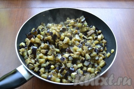 В сковороду влить половину растительного масла, выложить отжатые баклажаны. Обжарить баклажаны на среднем огне, помешивая, до мягкости (около 10 минут).
