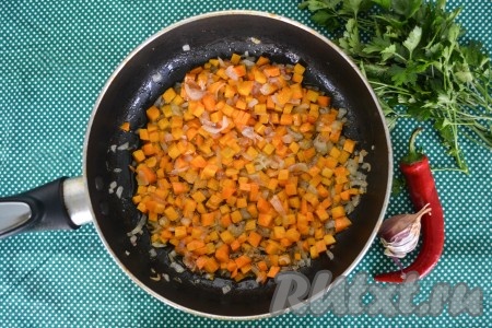 Лук и морковь очистить, нарезать мелкими кубиками. Разогреть сковороду, влить оливковое масло, выложить морковку с луком и обжарить их на среднем огне в течение 1-2 минут, иногда помешивая.
